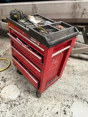 une boîte à outils rouge posée par terre à côté d'un camion