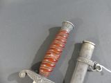 a knife that is laying on a table with a chain around it