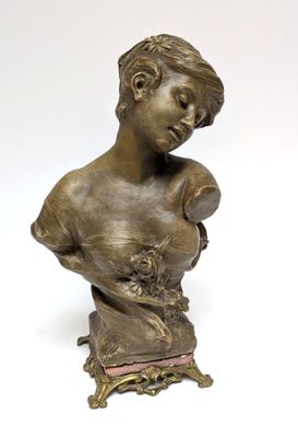 a bronze bust of a woman with a flower in her hand