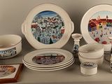 many plates and cups on a shelf with pictures on them