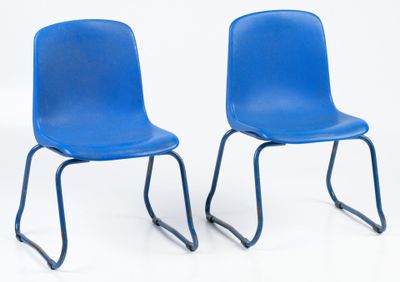 two blue chairs sitting next to each other on a white surface