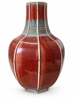 un vase rouge orné d'un motif bleu et blanc