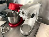 a red mixer sitting on a counter next to a red mixer