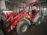 a red tractor that is parked inside of a building