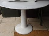 une table blanche sur laquelle est posée une fleur blanche
