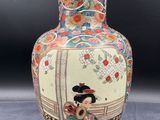 a vase with a woman on it sitting on a table