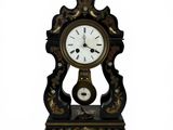 a black and gold clock sitting on a white surface