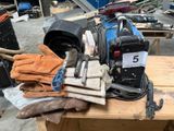 une pile de gants, de gants et d'autres outils posée sur une table