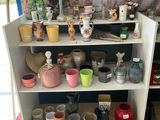 de nombreux pots et vases posés sur une étagère dans une pièce