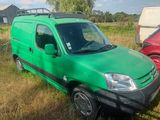 une camionnette verte garée dans l'herbe