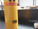 une bouteille d'eau jaune avec un bouchon noir posée sur une table