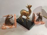 a statue of a deer, a bird, and a bird on a marble base