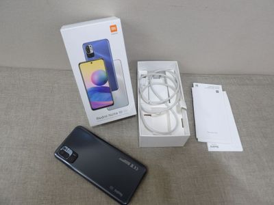 une image représentant une boîte contenant un téléphone et un chargeur posée sur une table
