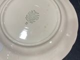 a white plate with a leaf on it on a table