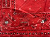 red bandanna with black and white designs on it on a table