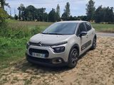 La voiture est garée sur le bord du chemin de terre.