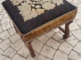 a small foot stool with a black and gold design on it