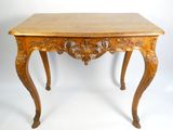 une table en bois dont le plateau est sculpté, sur fond blanc