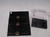 a black box with a watch on it next to a black box with a watch on it