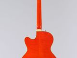 an orange guitar hanging from a string on a white background