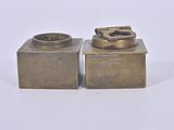 two metal objects that are sitting on a white surface