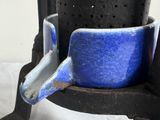 a blue cup sitting on top of an old stove
