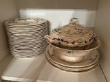several plates and bowls are stacked on a shelf in a cabinet