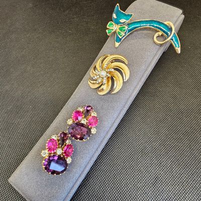 une broche violette et verte et une broche verte et violette