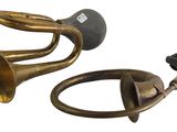 two brass trumpets and a black cord on a white background