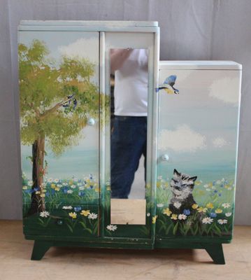 a man that is standing in front of a painted cabinet