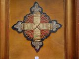 a picture of a cross on a wall hanging on a wall