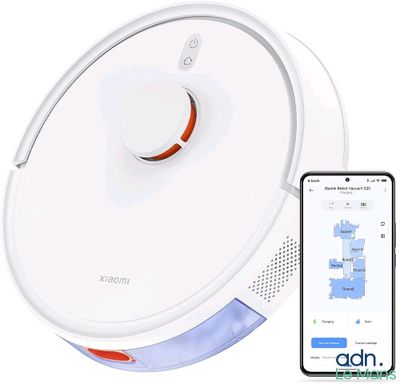 une image d'un aspirateur robot avec un téléphone à côté