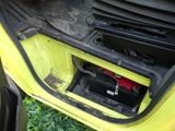 a small yellow car with a battery in the trunk