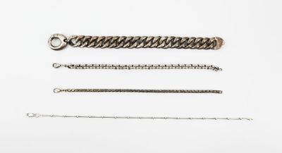 a group of silver chains on a white surface