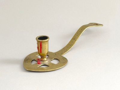 un petit porte-pipe en laiton posé sur une surface blanche