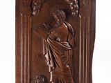 a carved wood plaque depicting a woman holding a child