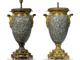 une paire d'urnes anciennes sur des socles, sur fond blanc