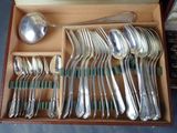 a lot of silverware in a box with a spoon and spoon rest