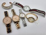 several watches and bracelets are sitting on a white surface