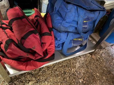 two bags sitting on a shelf next to each other