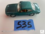 une petite voiture miniature avec une étiquette de prix à côté