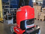 a red machine that is sitting in a warehouse