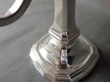 a silver candle holder on a table with a candle