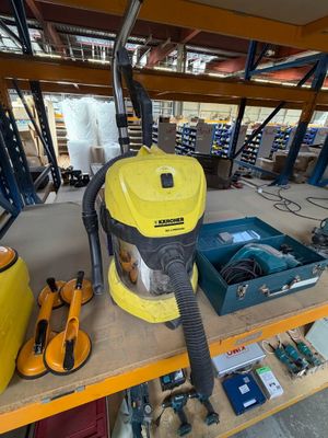 un aspirateur jaune et noir posé sur une étagère dans un garage