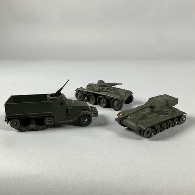 trois véhicules militaires miniatures posés sur une surface blanche