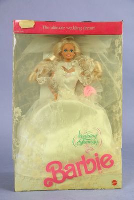 barbie doll in a box with a white dress and pink shoes