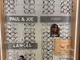 many pairs of glasses on display in a display case