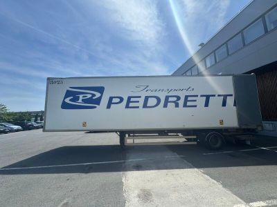un semi-remorque garé devant un immeuble
