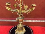 un vase doré avec des fleurs sur une surface rouge