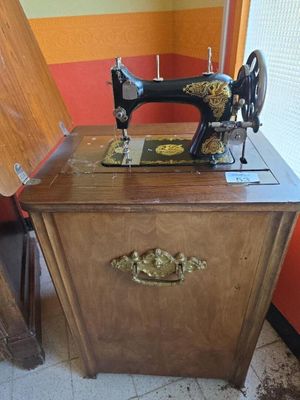 a sewing machine sitting on top of a wooden cabinet